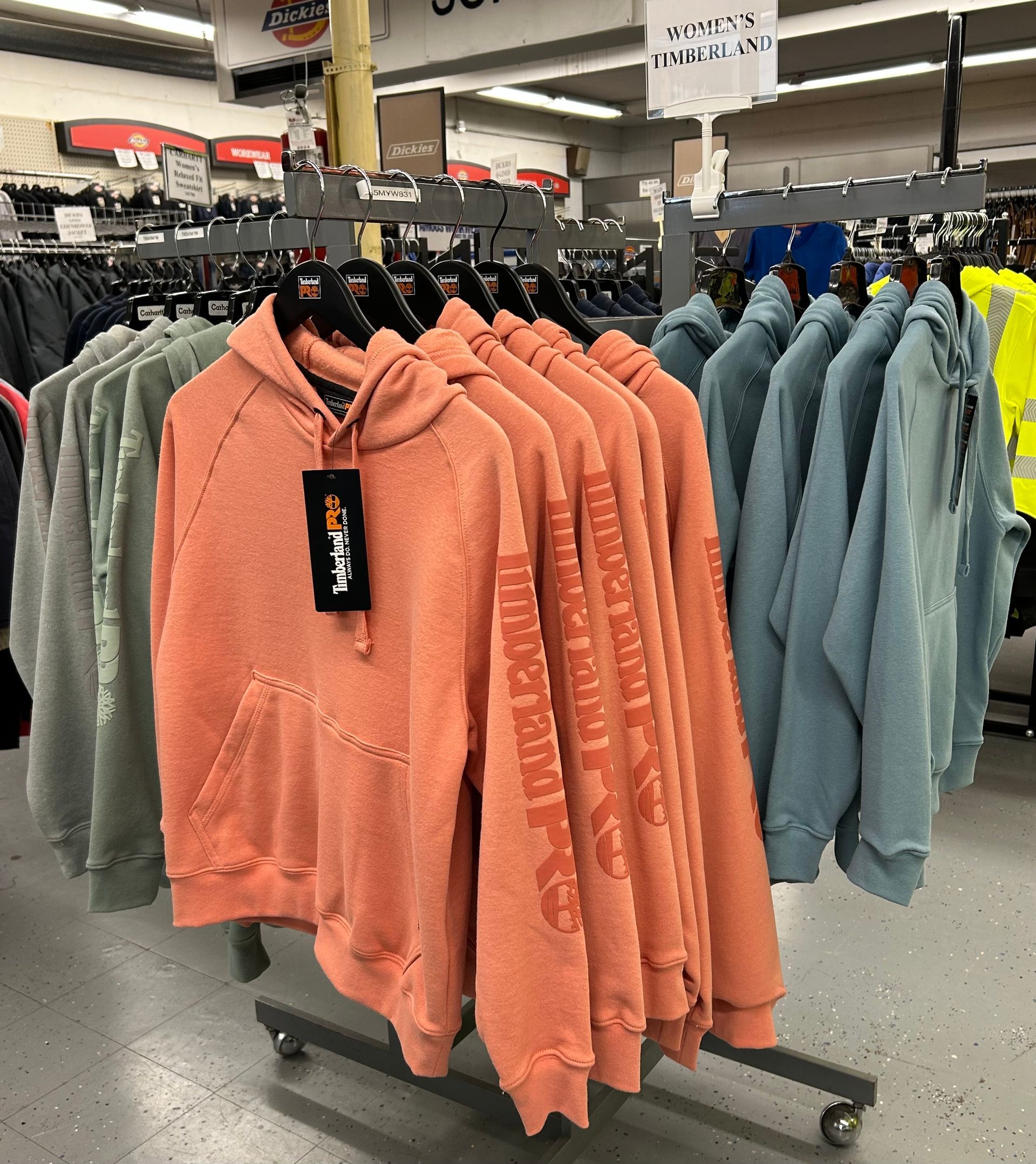 A bunch of hoodies are hanging on a rack in a store.