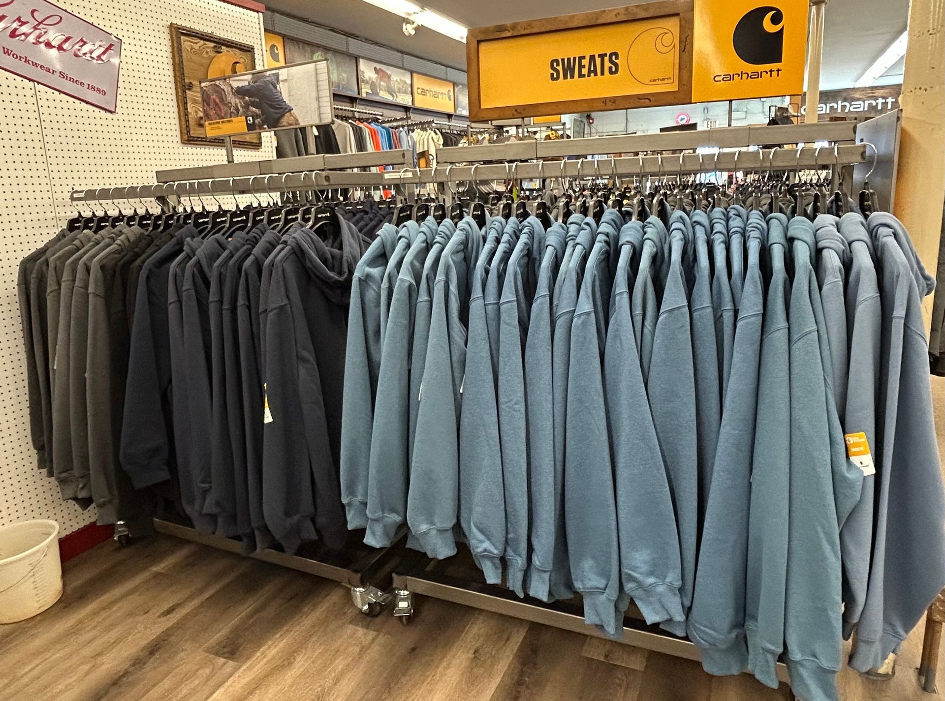 A display of sweatshirts hanging on a rack in a store.
