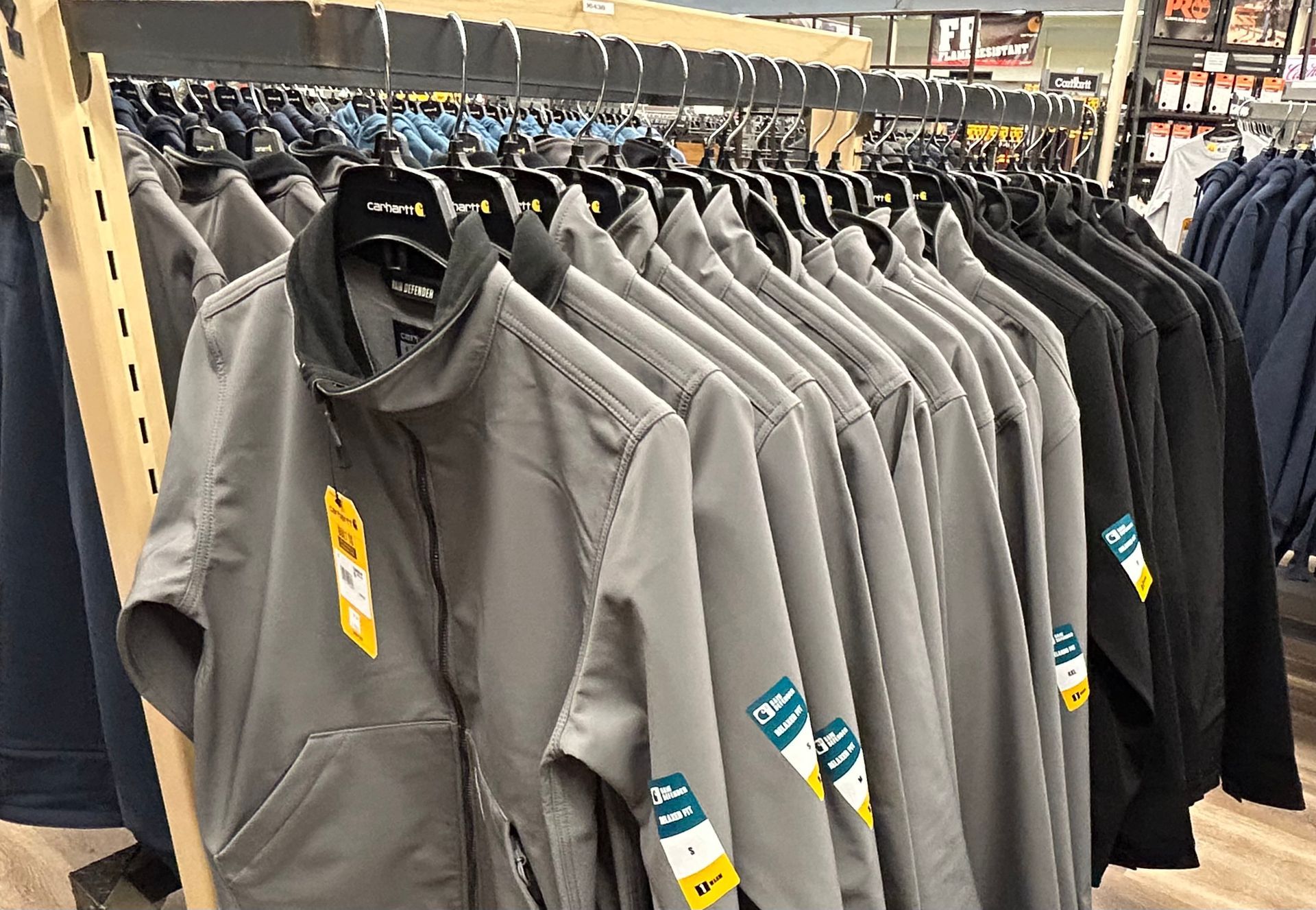 A row of jackets hanging on a rack in a store.