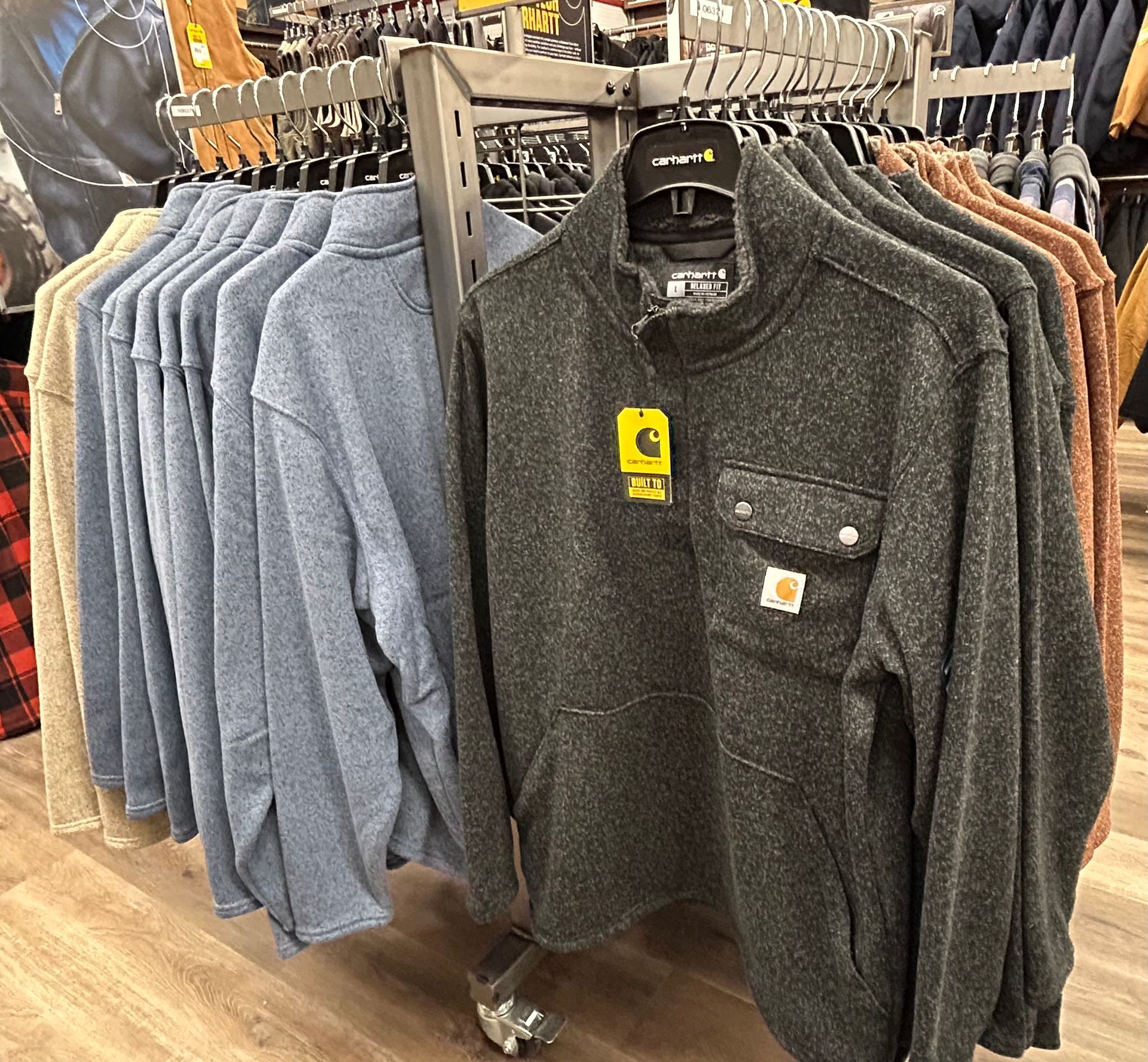 A display of sweaters hanging on a rack in a store.