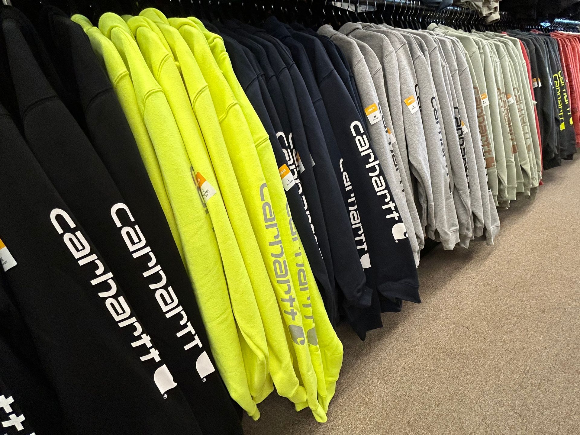 A row of carhartt sweatshirts are lined up in a store