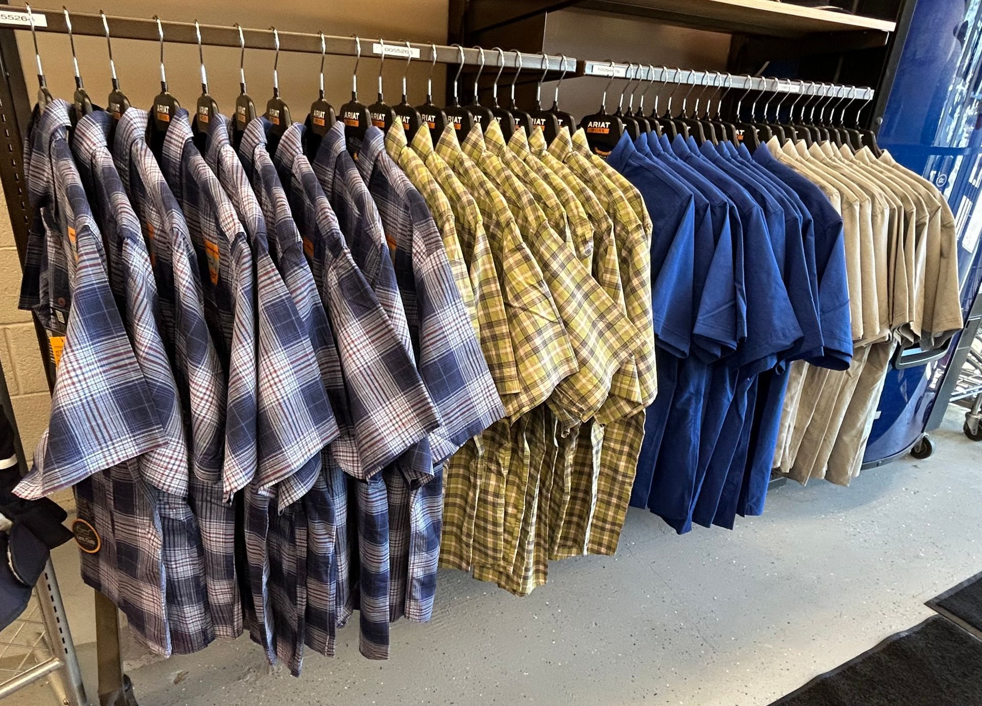 A bunch of shirts are hanging on a rack in a store