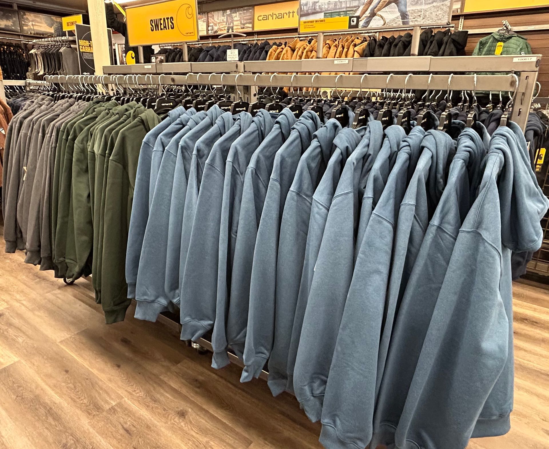 A row of clothes hanging on racks in a store.