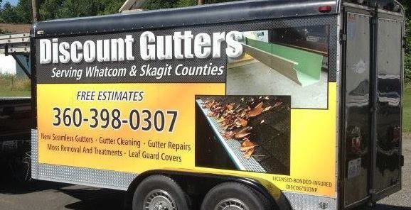 Discount Gutters service trailer with black, yellow, and green signage and phone number 360-398-0307