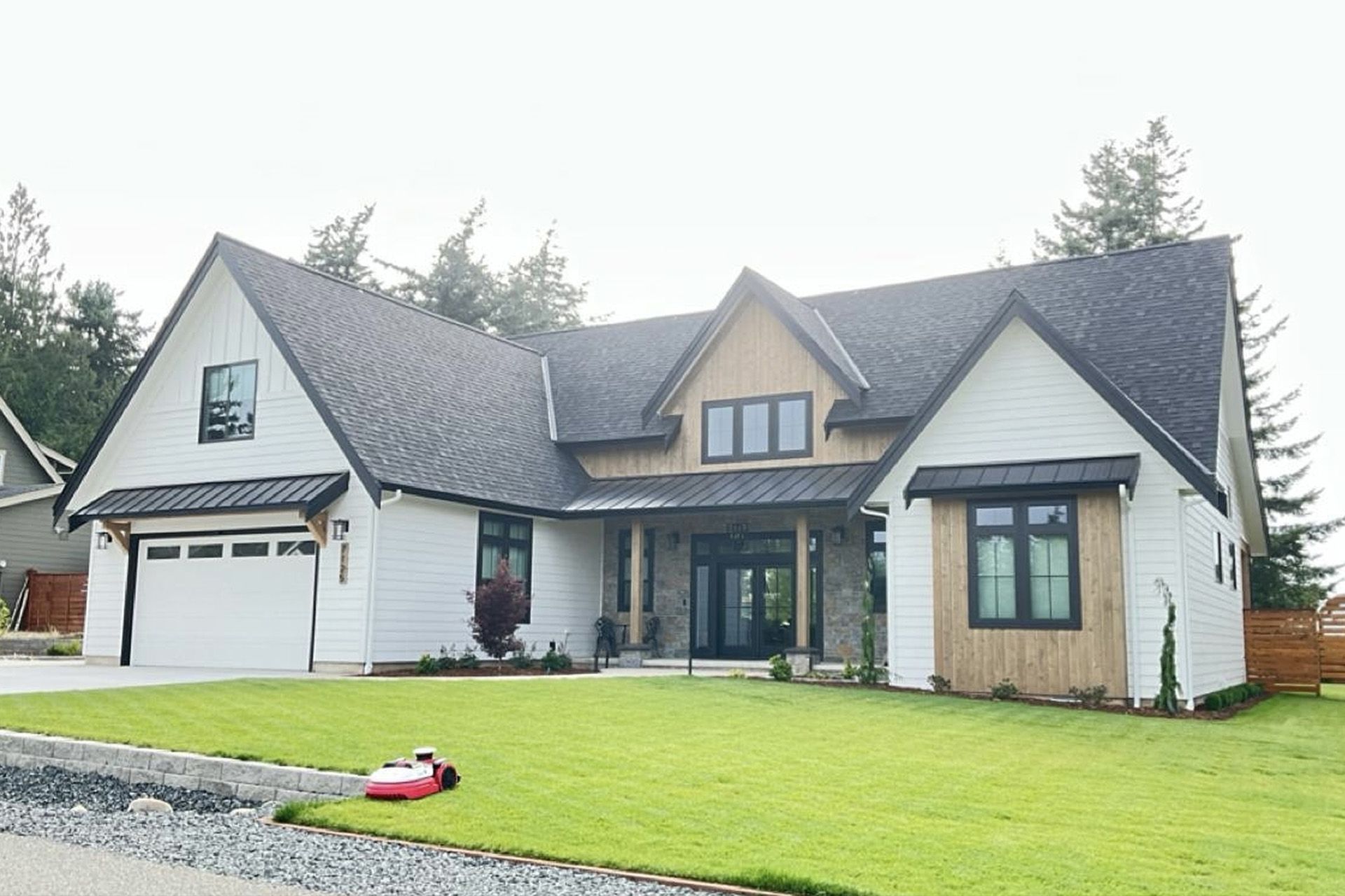 Large suburban house with gray roof, white siding, and a green lawn