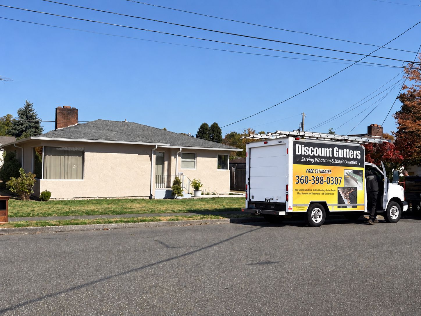 Discount Gutters truck outside a Lynden, WA home with new Low Gloss White seamless gutters and downspouts.