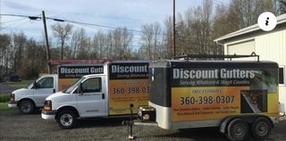 White truck and trailer for Discount Gutters parked beside a road on a sunny day