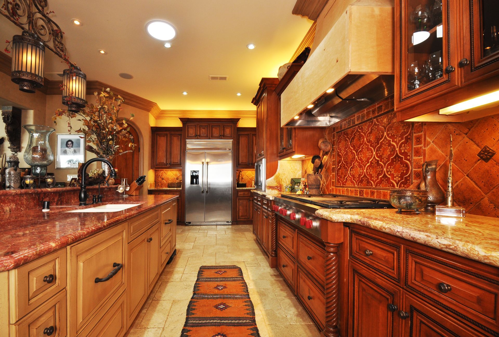 Kitchen with dark wood cabinetry, stainless steel appliances, and two-tone countertops.