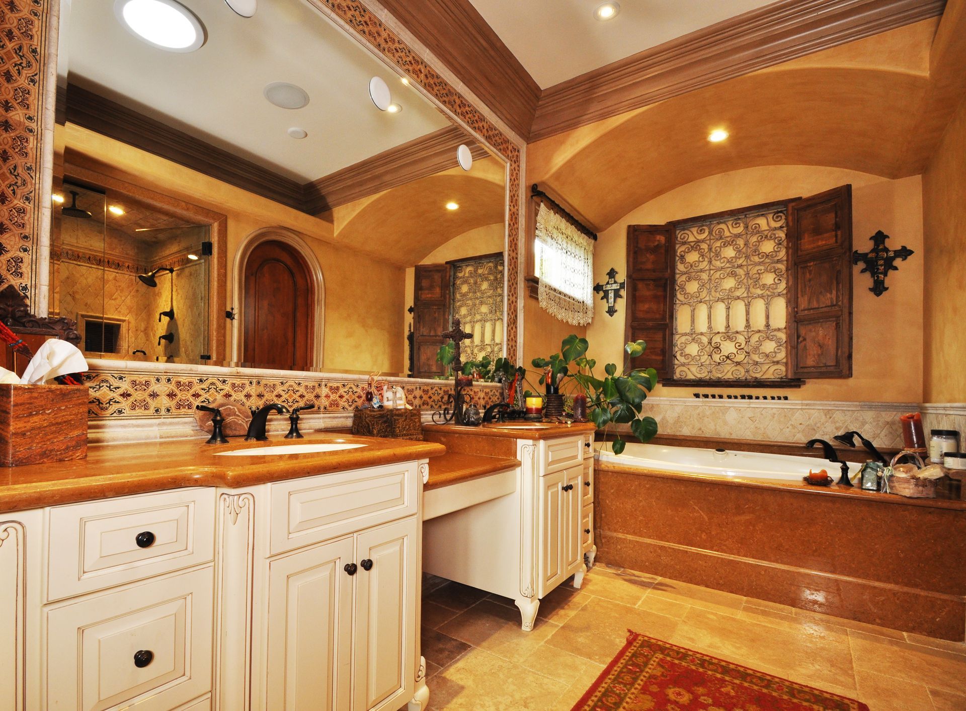 Bathroom with white cabinets, wooden trim, and a patterned window.