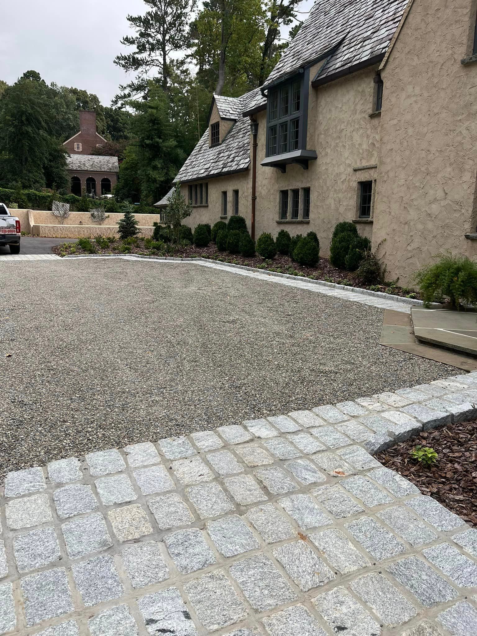 There is a gravel driveway in front of a house.