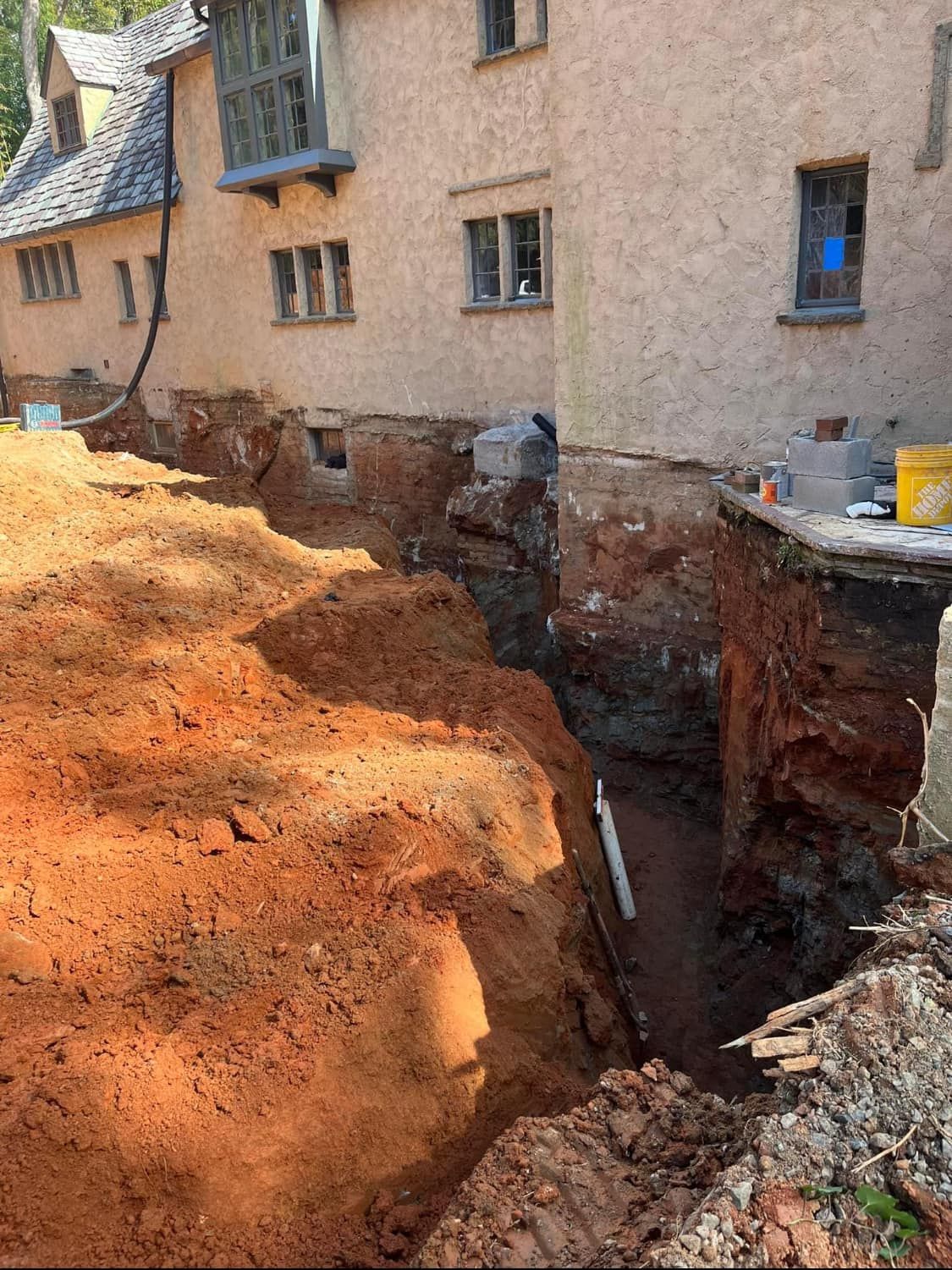 A large pile of dirt is sitting in front of a house.