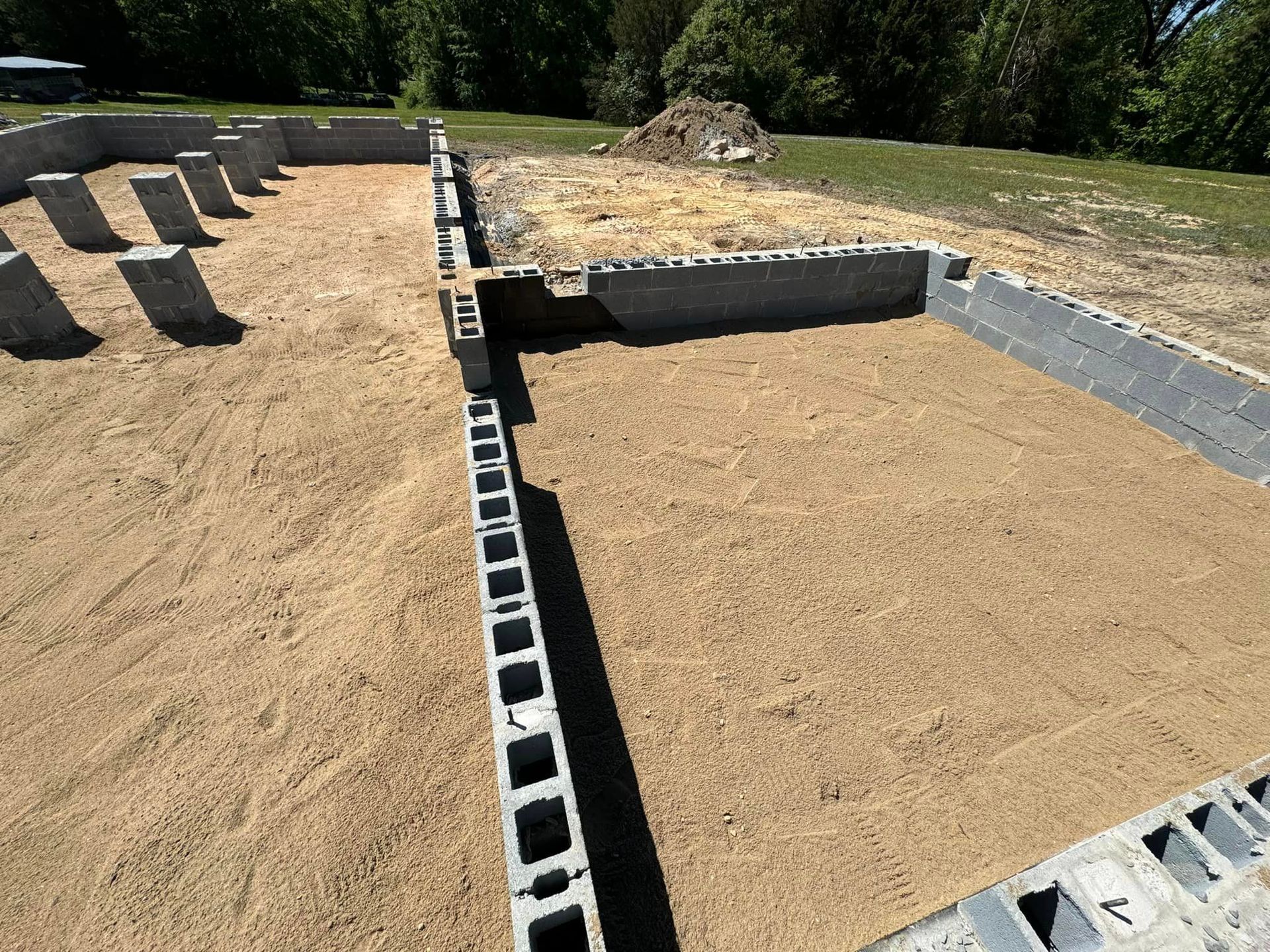 A foundation for a house is being built on a dirt field.