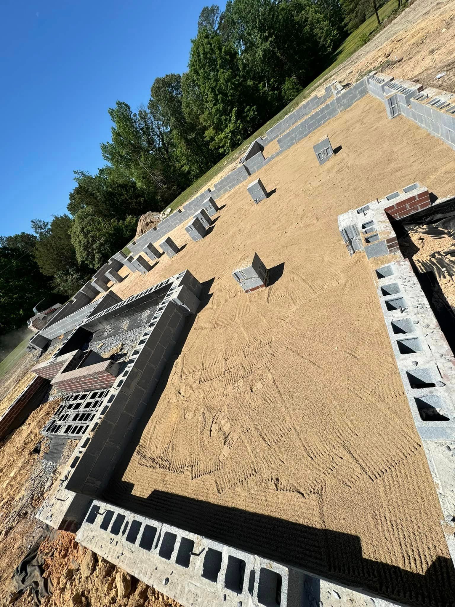A foundation for a house is being built on a dirt field.