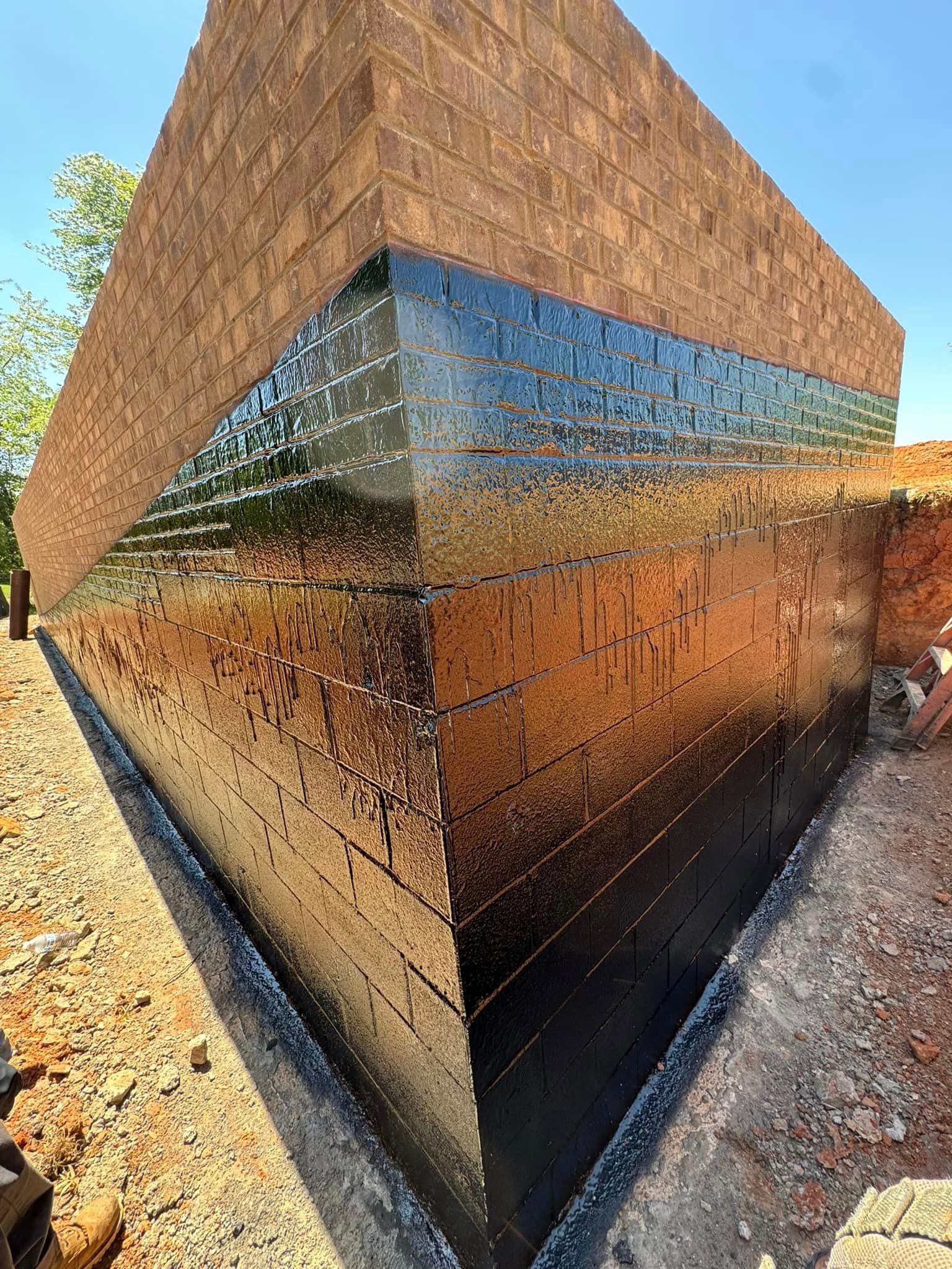 A large brick building is being built in the dirt.