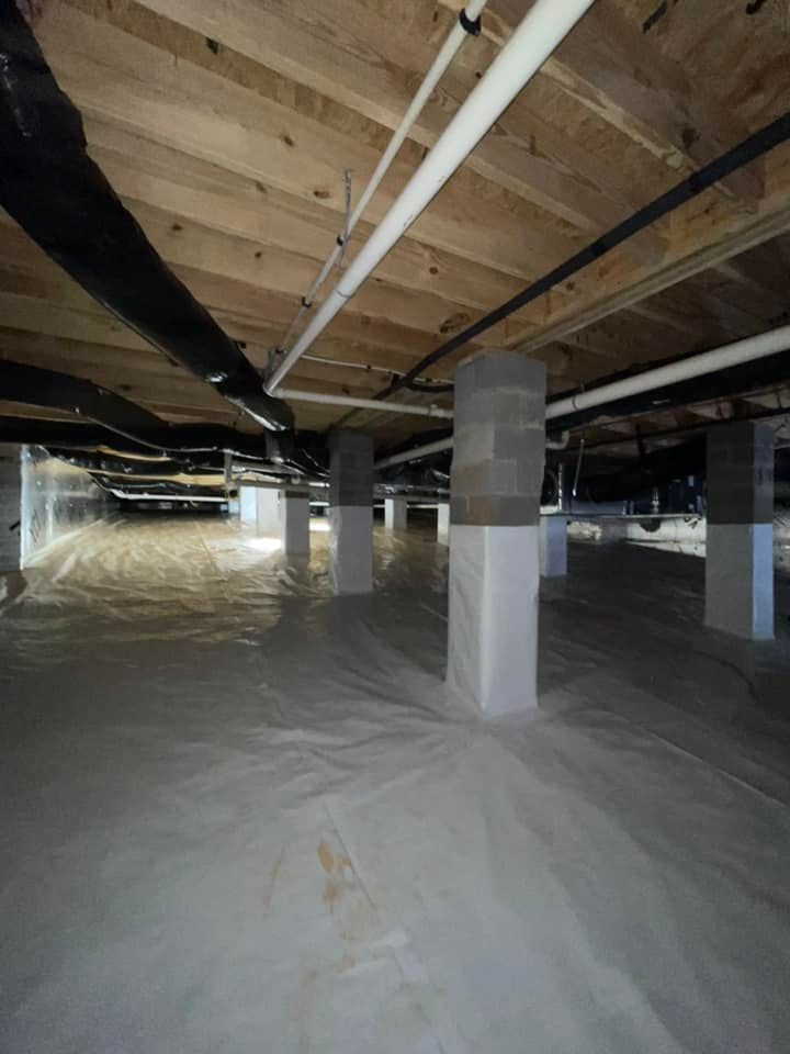 An empty basement with a lot of pipes and pillars.