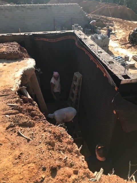 Two men are working in a hole in the ground