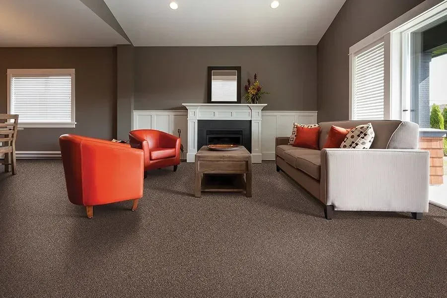Living room with gray walls, fireplace, orange armchairs, and beige sofa.