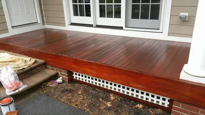 Newly stained wooden porch with white lattice, overlooking a yard.