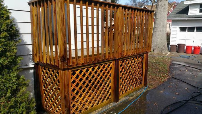Wooden deck with latticework base, stained brown.