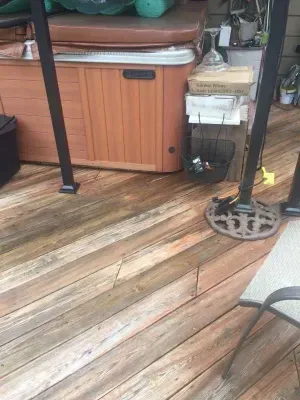 Wooden deck with hot tub, and two black pole supports.