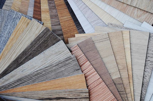 A fan-shaped display of various wood grain veneer swatches, ranging in color from light ash and beige to dark walnut tones.