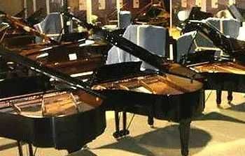 A group of grand pianos are sitting next to each other in a room.