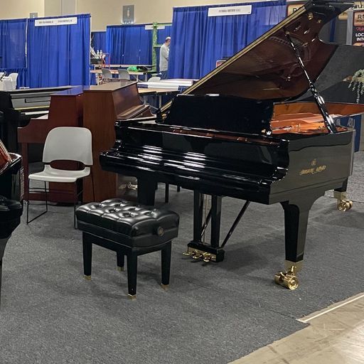 A black grand piano with a stool in front of it