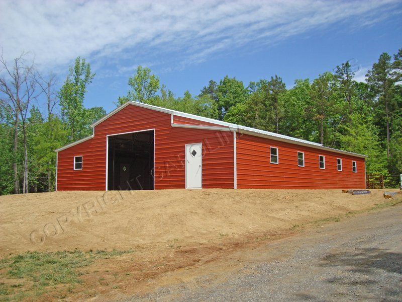 A large red barn with a white door and windows