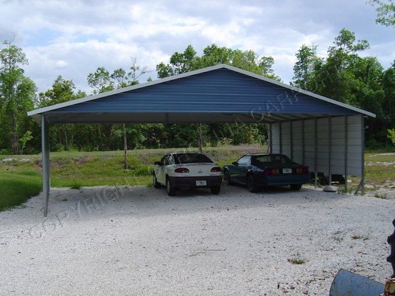Two cars are parked under a blue carport