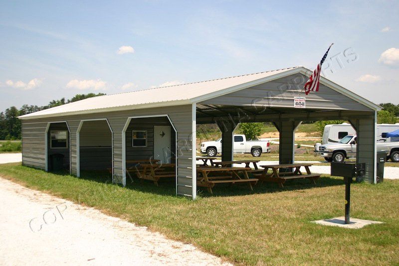 A large metal building with a picnic area underneath it.