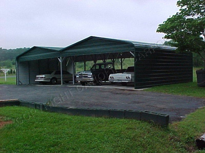 Two cars are parked under a canopy in a parking lot