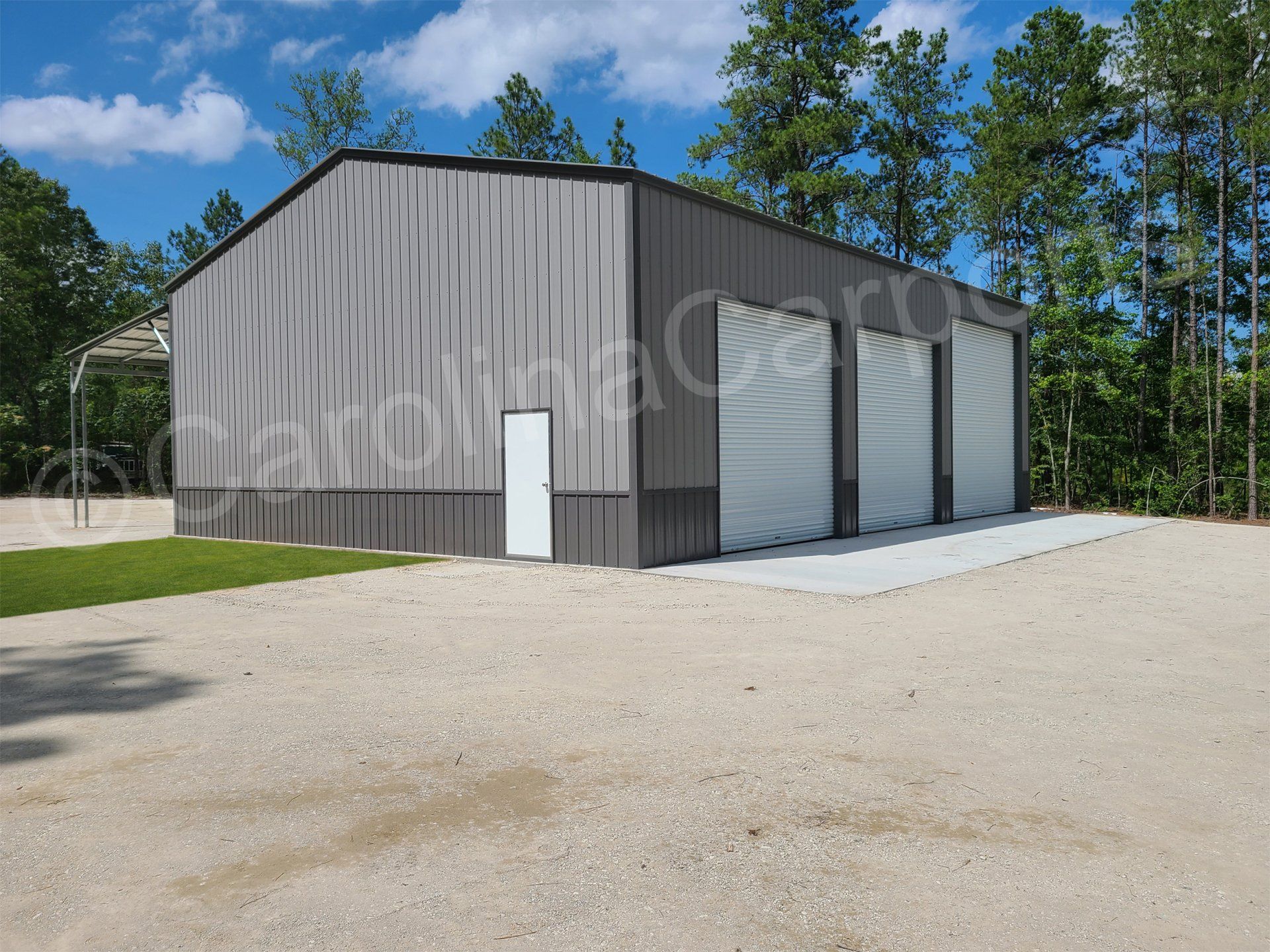 A large metal building with a concrete driveway in front of it