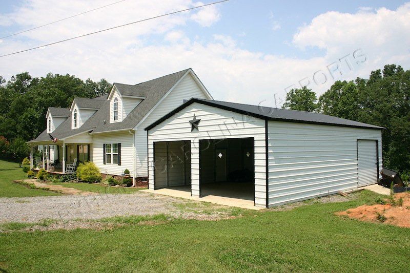 A white house with a large garage in front of it