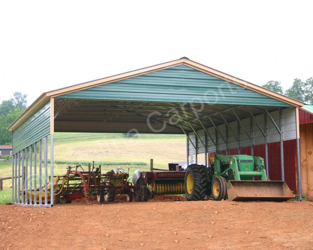 A green john deere tractor is parked under a carport.