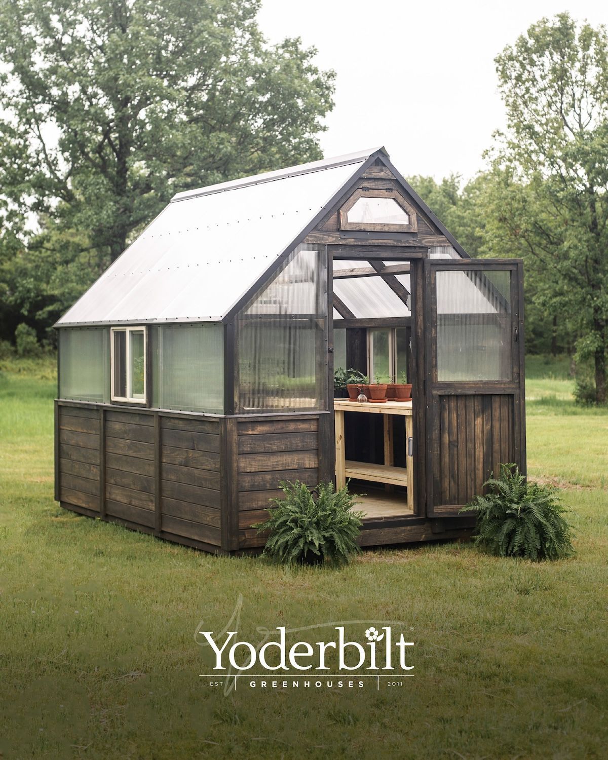 Greenhouse constructed of weathered wood, with open doors