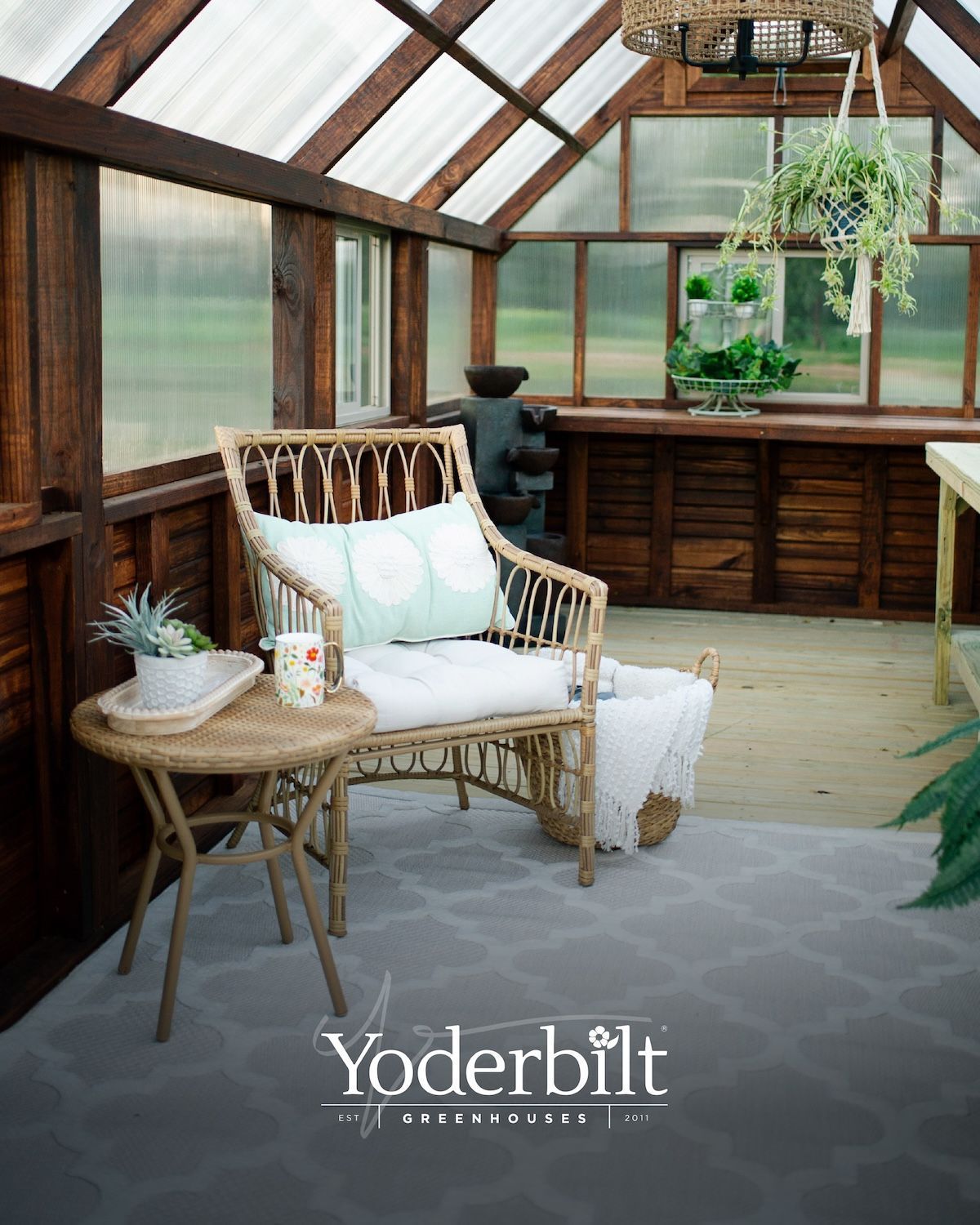 Cozy greenhouse interior with wicker chair, table, rug, and plants