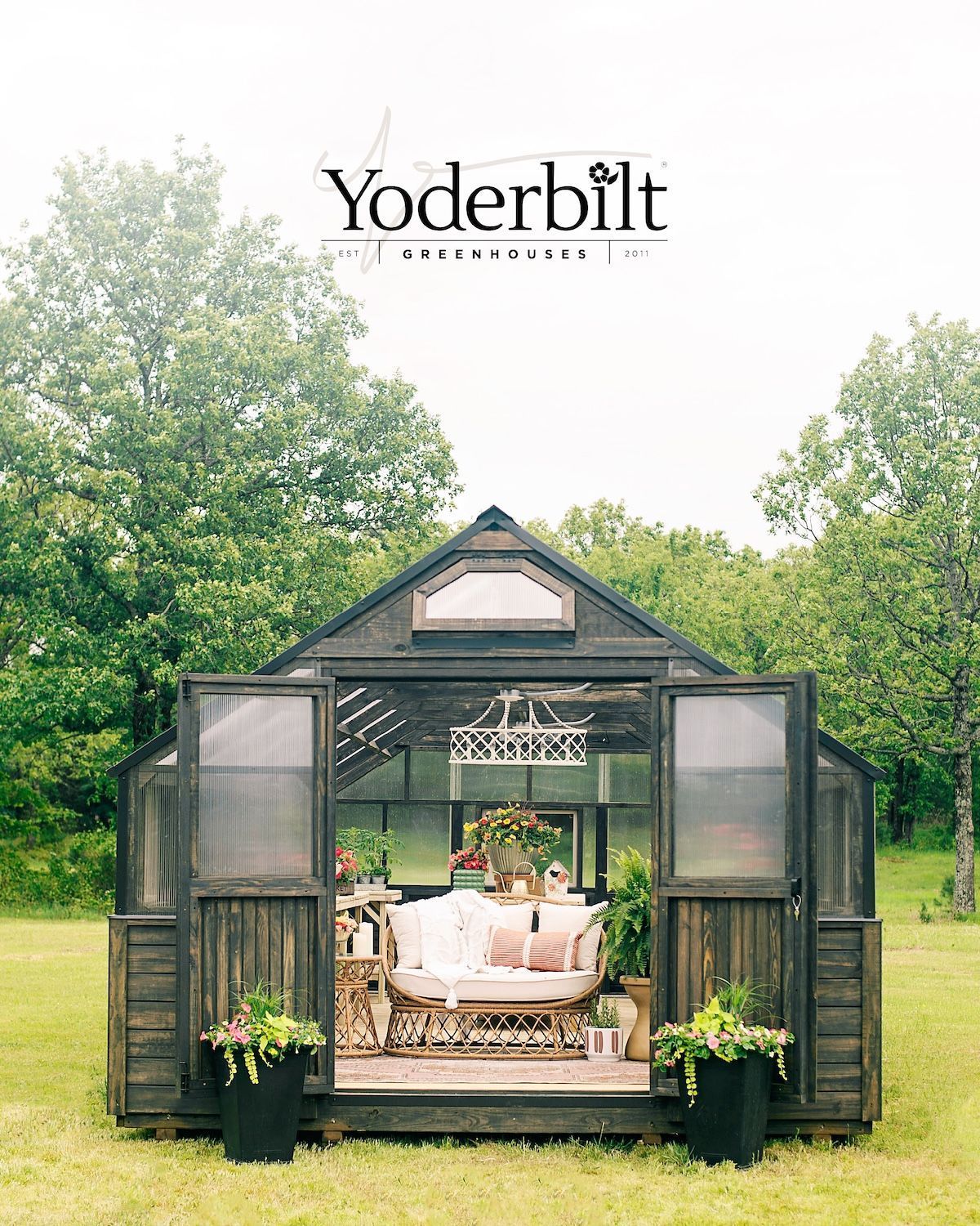 A dark-stained greenhouse with open doors