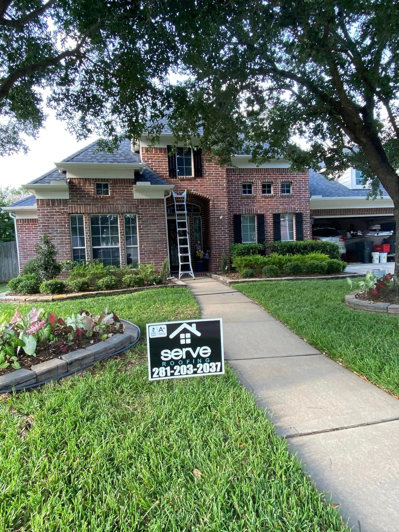 A house with a sign on the sidewalk in front of it.