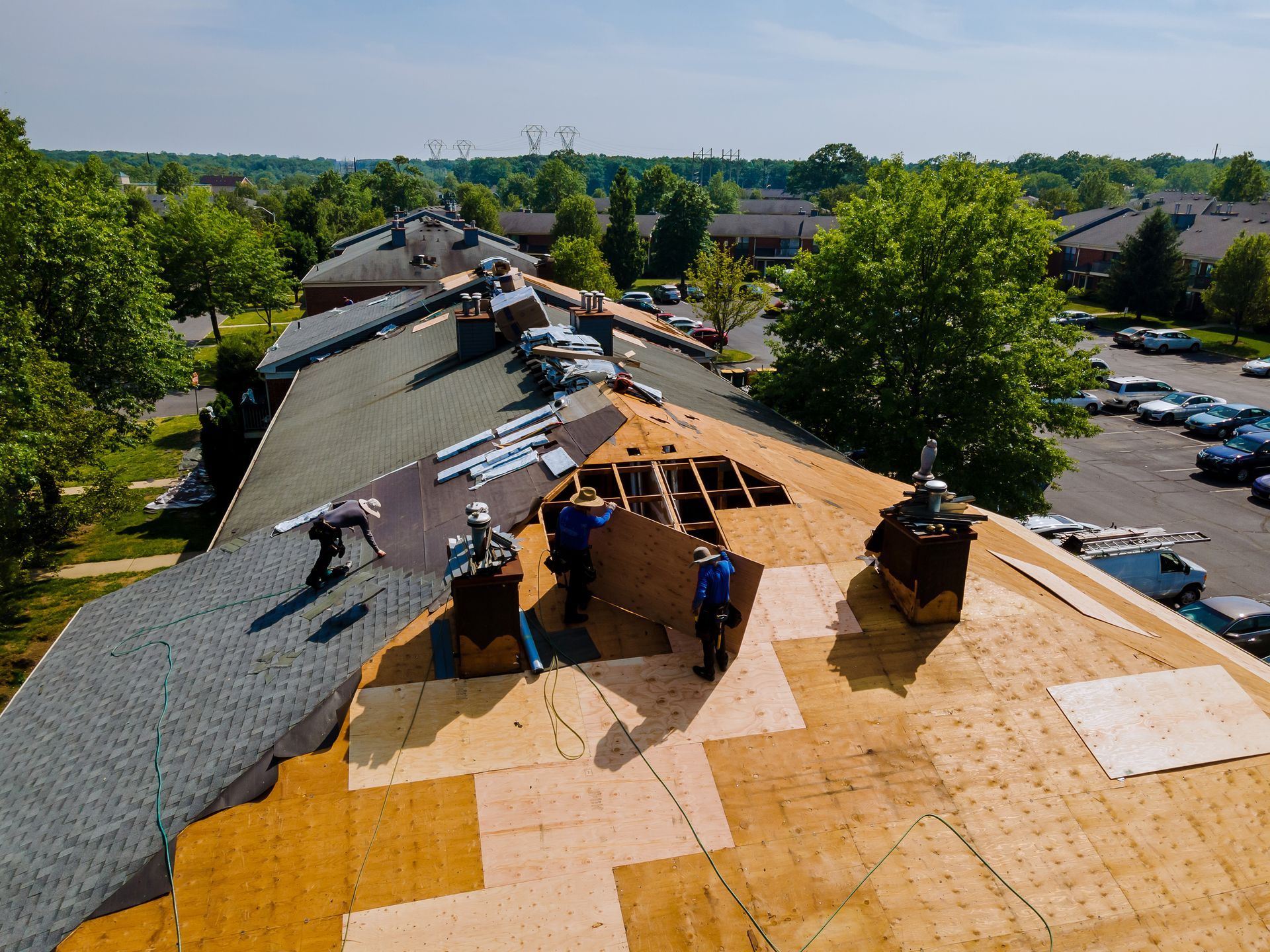 A group of people are working on a roof in a residential area.