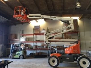 A forklift is parked next to a lift in a warehouse