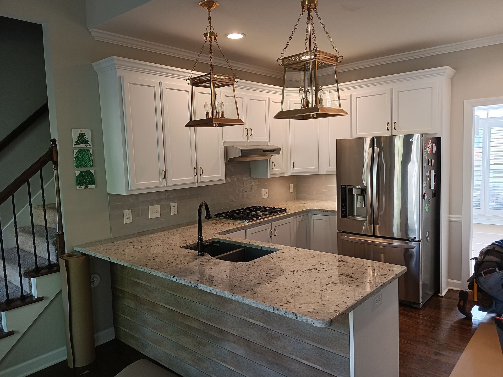 Modern kitchen with white cabinets, granite countertops, and stainless steel appliances.