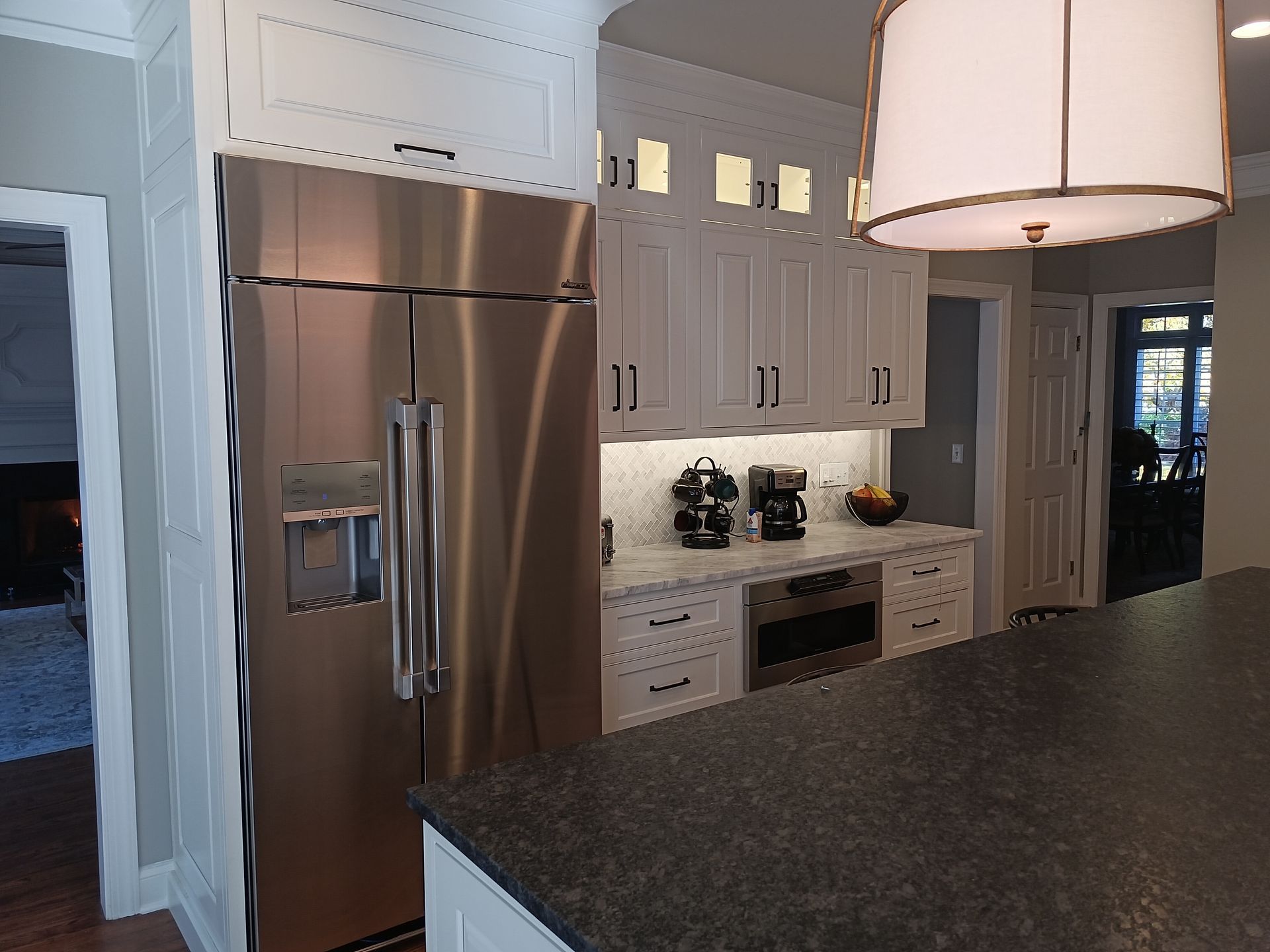 Stainless steel refrigerator in a bright white kitchen.