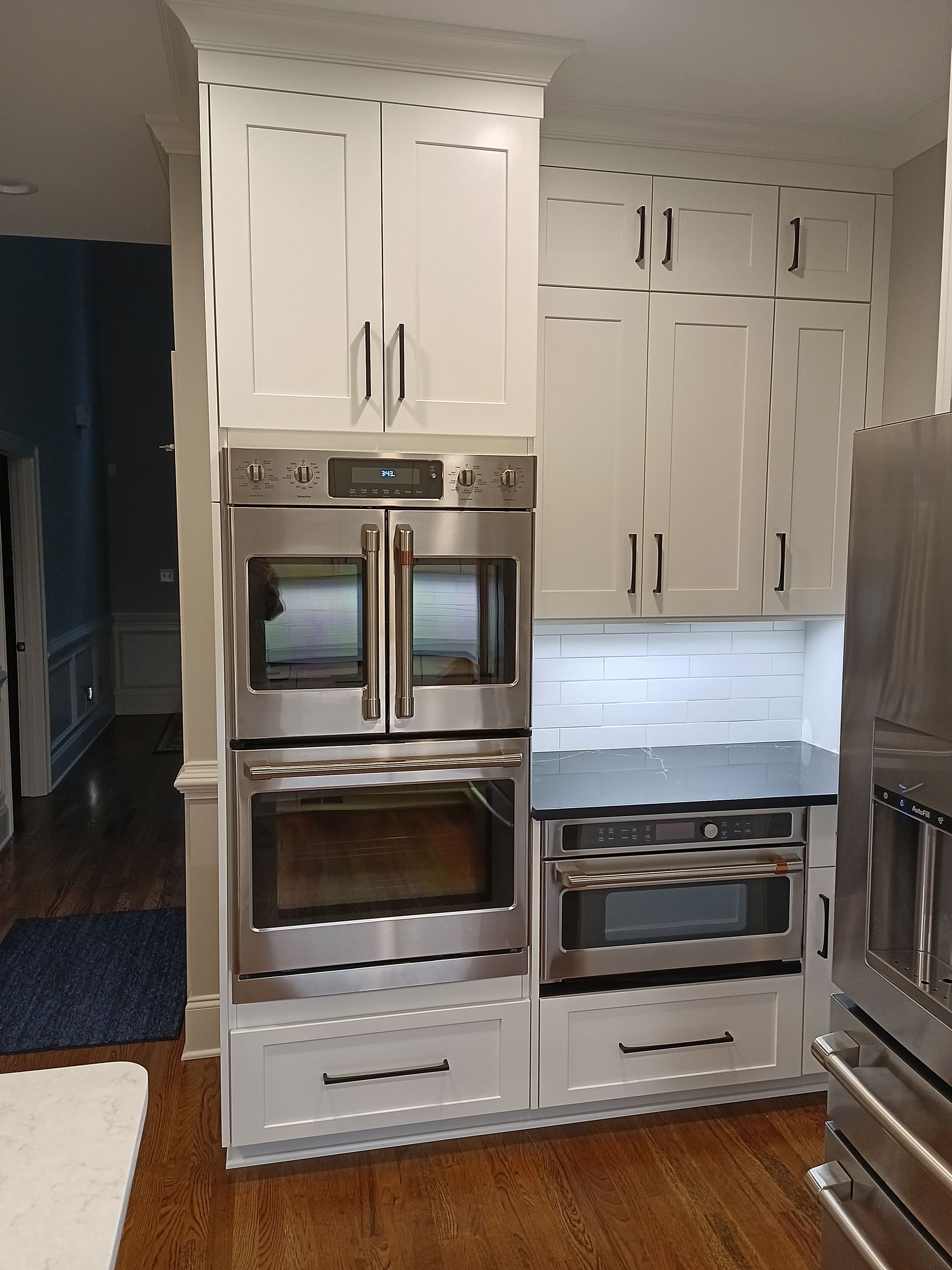 White kitchen cabinets with stainless steel appliances.