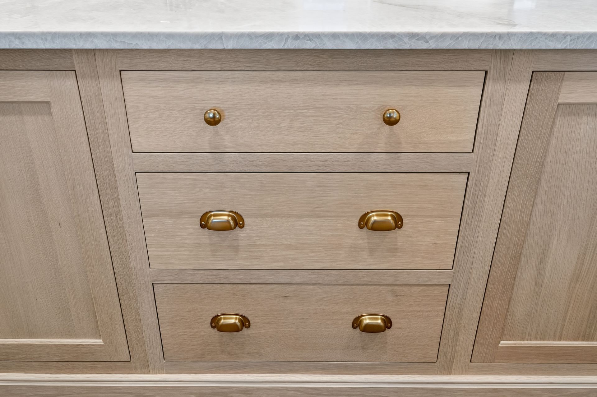 Wooden cabinet drawers with gold hardware.