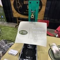 Tabletop display with green stand and sign reading “The future is nowhere but in our hands.”