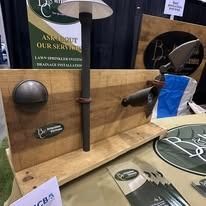 Display of metal hardware on a wooden board at a trade show booth