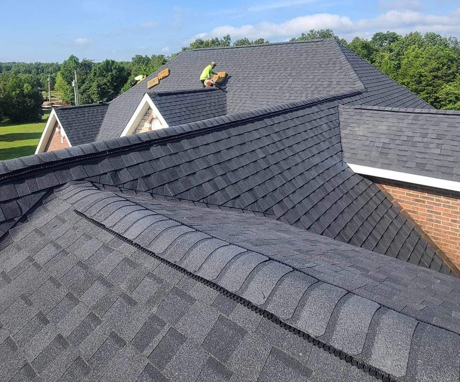 A man is working on the roof of a house.