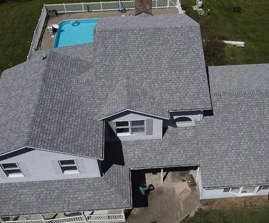 An aerial view of a house with a pool in the backyard.