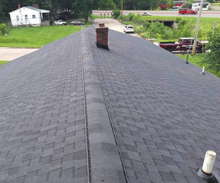 A black roof with a chimney on top of it
