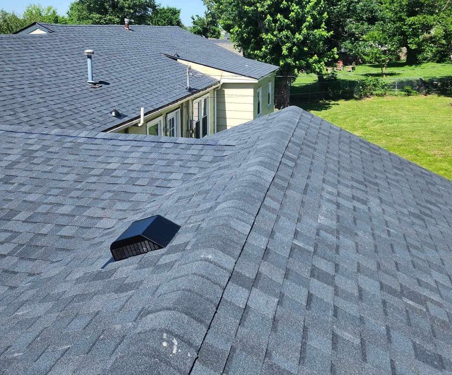 The roof of a house with a gray shingle roof.